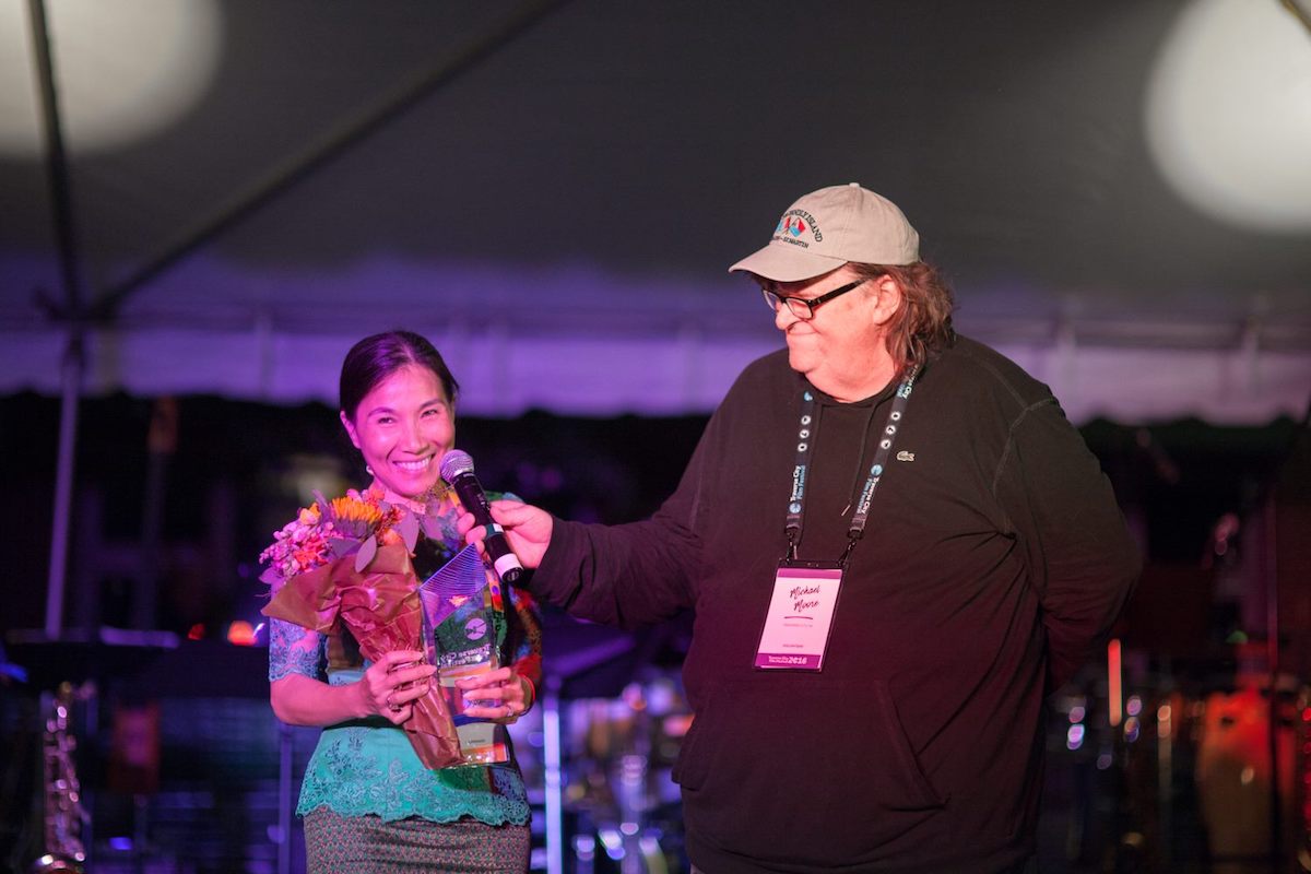 Director Sotho Kulikar of The Last Reel accepts the Founders' Prize for Best Film with Michael Moore at Traverse City Film Festival