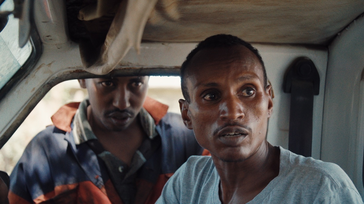 Ivory dealer “X” (outside car window) and poacher Lukas wait for the wildlife rangers to pass. From When Lambs Become Lions, directed by Jon Kasbe. Courtesy of Kasbe Films / The Documentary Group.