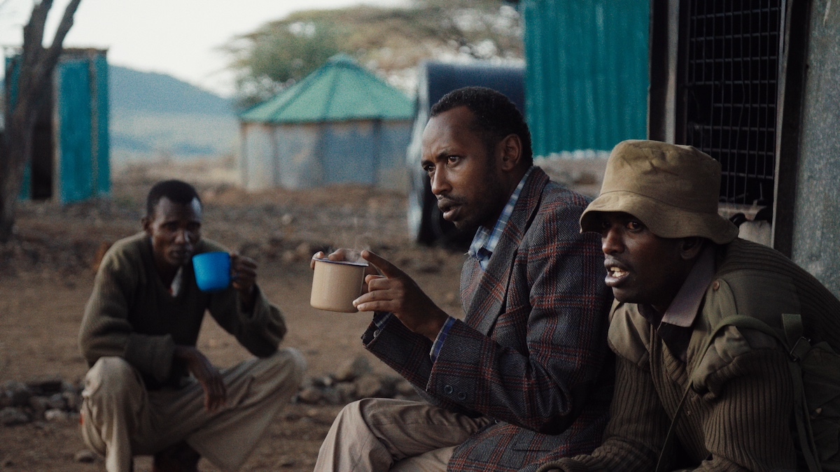 Ivory dealer “X” (left in foreground) visits the wildlife ranger unit of his cousin Asan (at right). From When Lambs Become Lions, directed by Jon Kasbe. Courtesy of Kasbe Films / The Documentary Group.