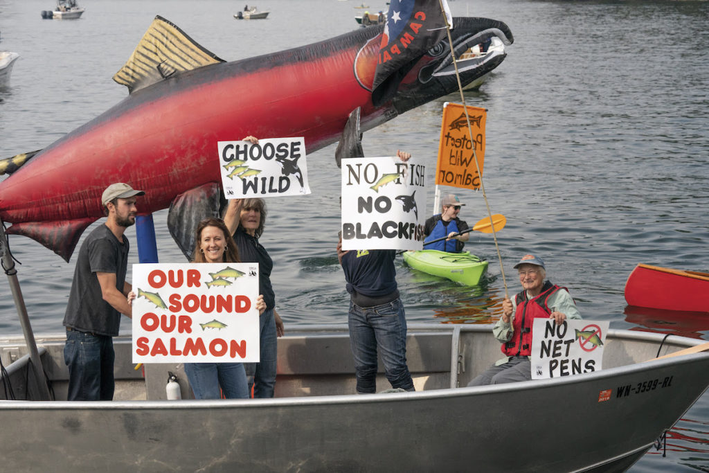 "Concerned citizens protest net-pen salmon farms at a Cooke Aquaculture facility. Eight months later, the state legislature voted to stop renewal of leases for Atlantic salmon net pens in Puget Sound. Bainbridge Island, Washington." PATAGONIA FILM “ARTIFISHAL”  Photo credit: Ben Moon