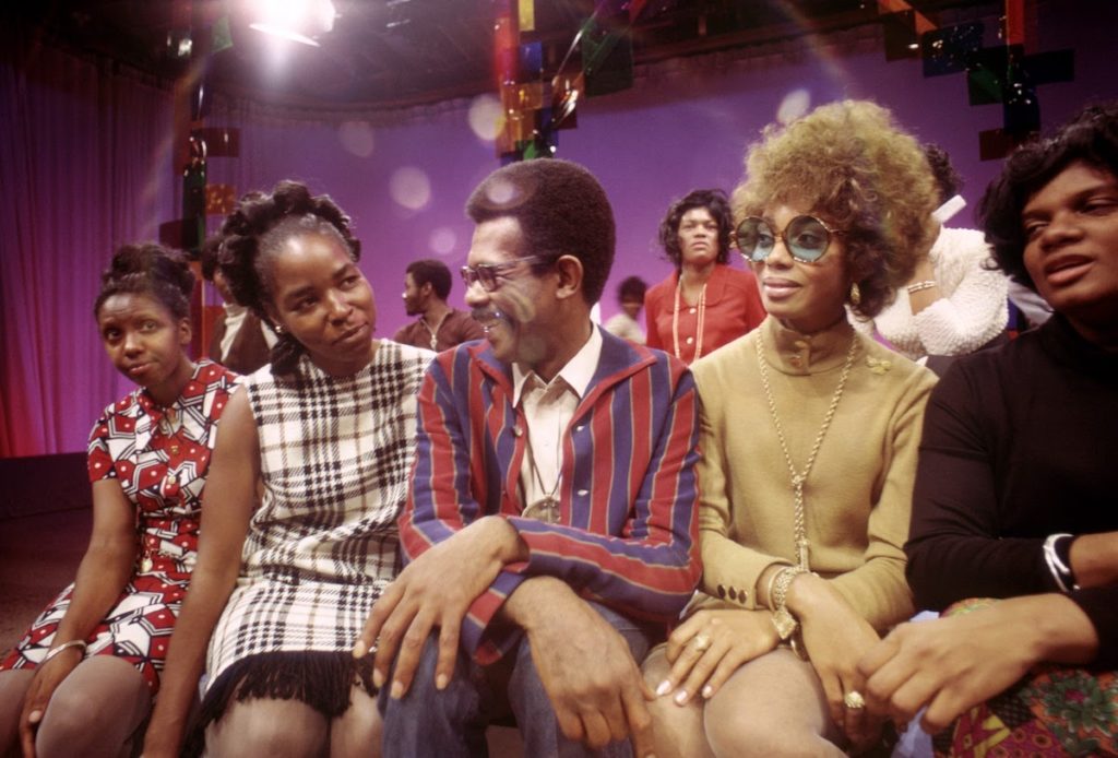 On the set of SOUL!, Host Ellils Haizlip (middle) is surrounded by members of the J.C. WHITE SINGERS after their moving performance