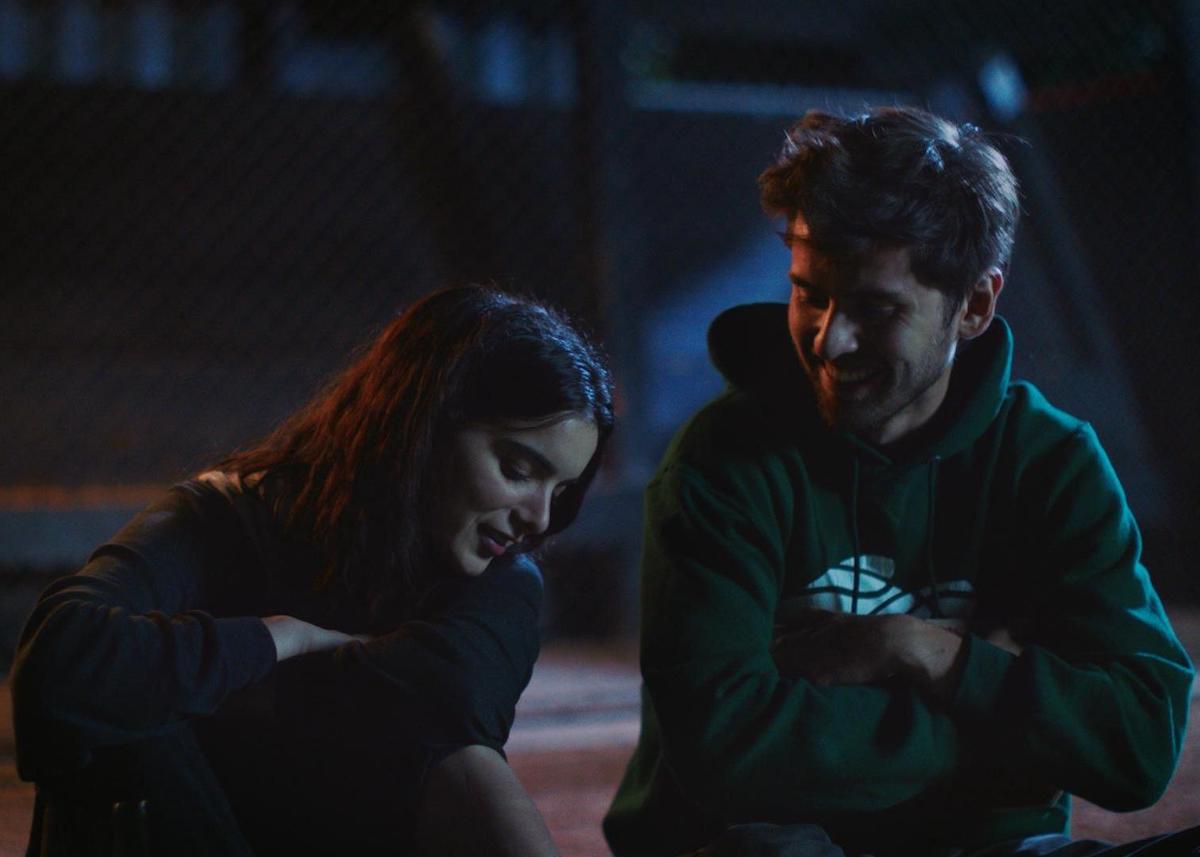 Maggie and Alex talk by the baseball field in Shithouse. 